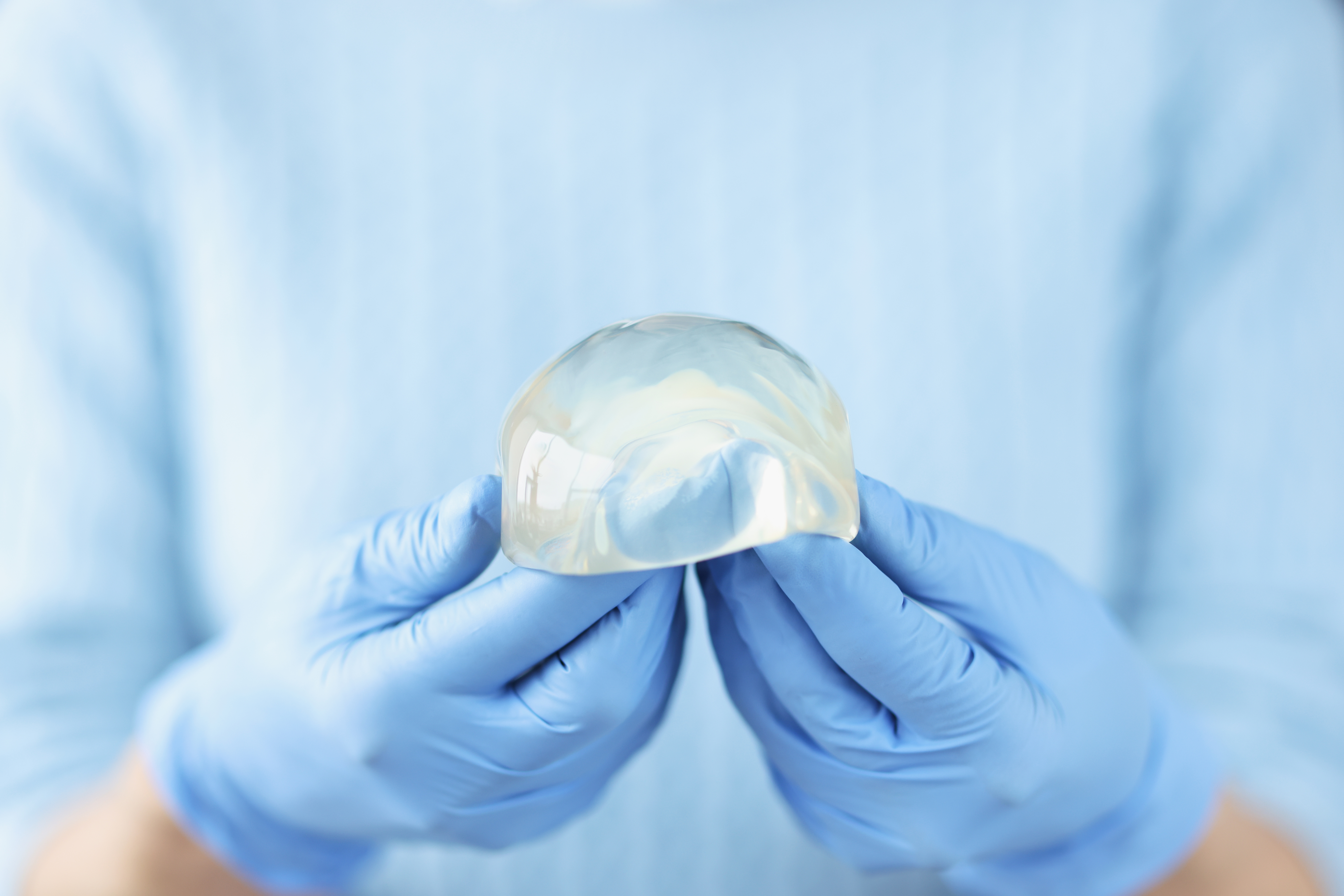silicone-breast-implant-hands-doctor-breast-augmentation-plastic-surgery-concept